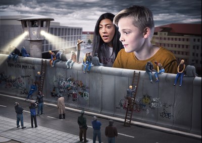 Mädchen und Junge schauen sich den Abriss der Berliner Mauer in Miniatur im Little BIG City Berlin an